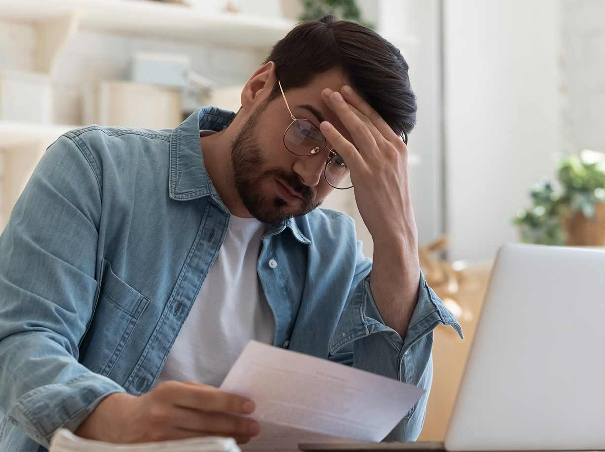 hombre con camisa blanca y jeans azules sentado sobre panel solar blanco y negro